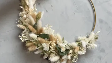Floraler Kranz auf grauem strukturiertem Hintergrund.