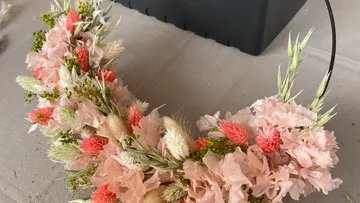 Floral crown made of pink and peach flowers.