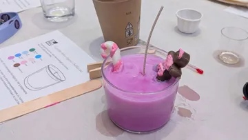 Purple candle with decorations on crafting table.