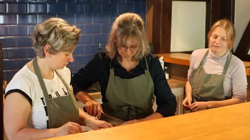 Drei Frauen kochen in einer Küche.