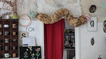 Getrocknete Blumen über Tür in kunstvollem Raum.