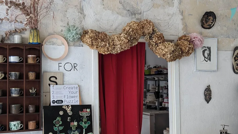 Dried flowers above doorway in artsy room.