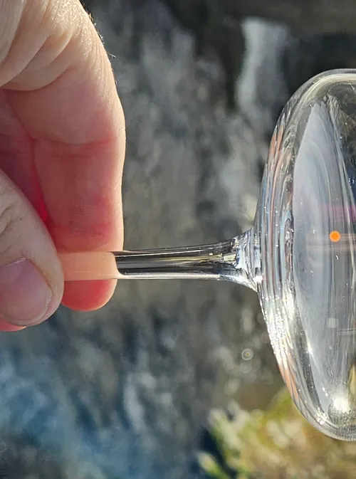 Hand holding magnifying glass over blurred background.