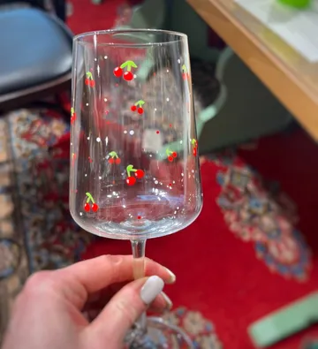 Clear wine glass with cherry pattern.