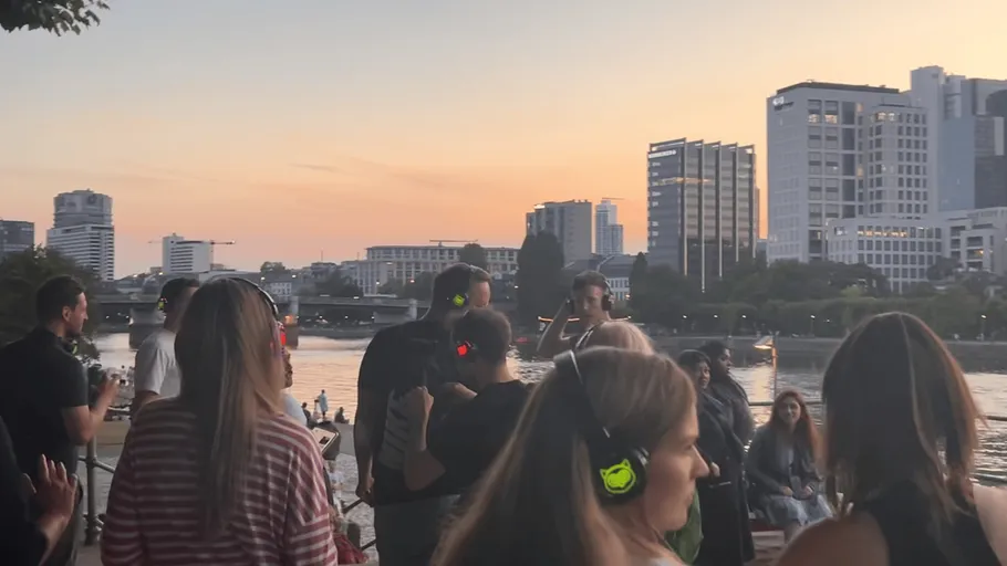 People wearing headphones enjoying a riverside party.