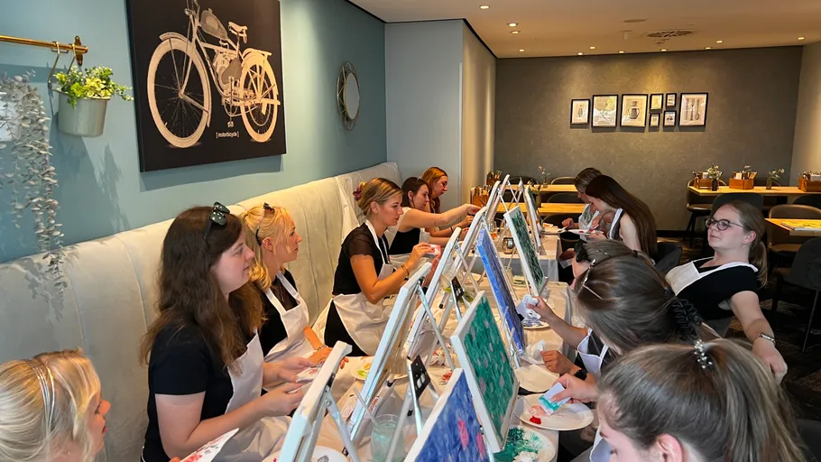 Women painting canvases in a cozy studio.