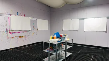 Art studio with paint tools on shelves.
