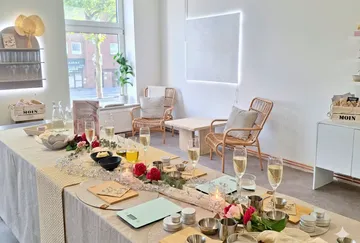 Table with drinks and flowers in cozy room.