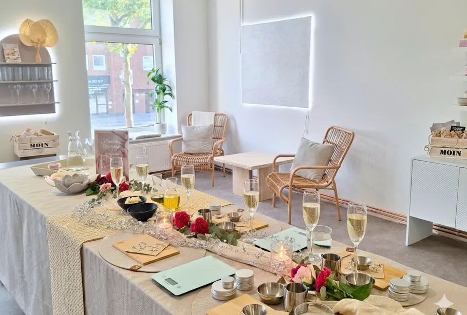 Table with drinks and flowers in cozy room.
