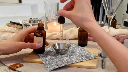 Hände nutzen Pipette mit ätherischen Ölen, gemütliche Umgebung.