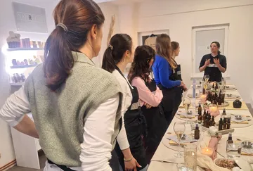 Women in aprons listen to a workshop instructor.
