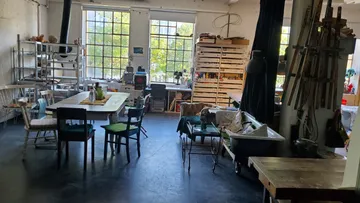 Art studio with tables and chairs, natural light.