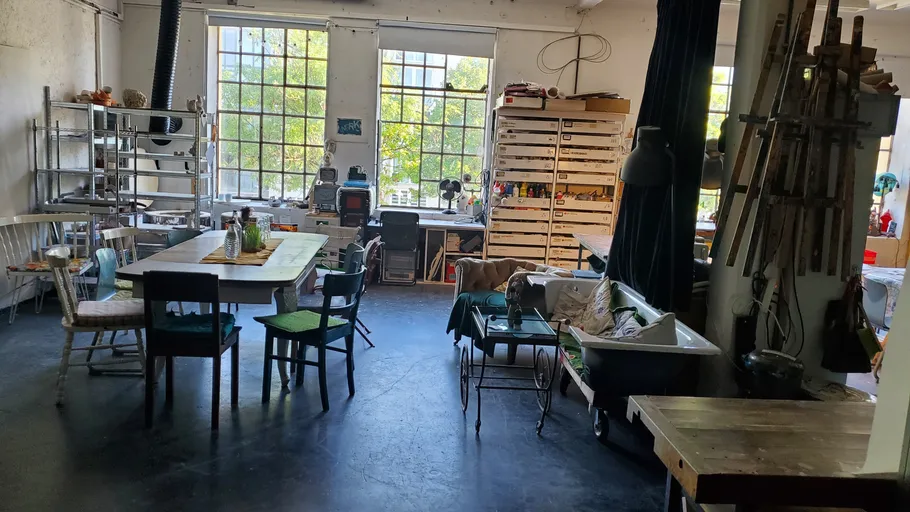 Kunststudio mit Tischen und Stühlen, Tageslicht.