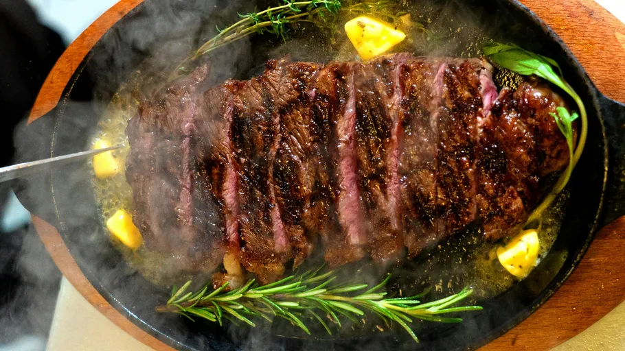 Sliced steak on a sizzling skillet.