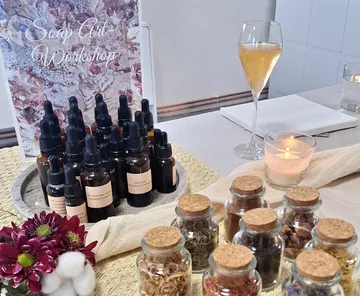Workshop table with bottles, jars, and candle.
