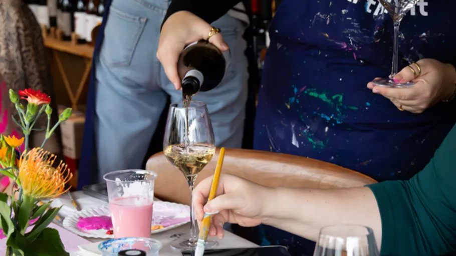 Wein wird beim Malen am Tisch eingeschenkt.