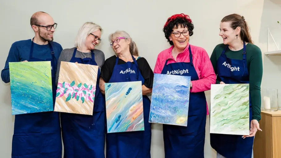 Five people holding paintings at ArtNight event.
