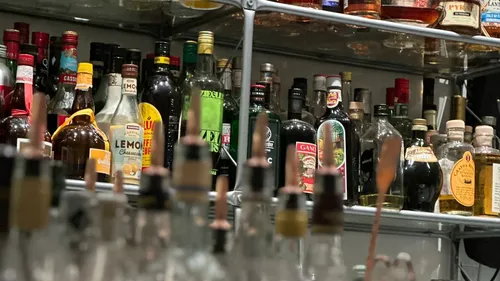 Alkoholflaschen auf Metallregalen angeordnet.