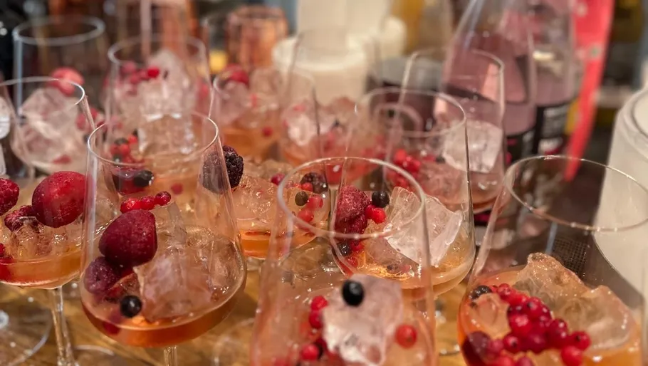 Glasses of iced drinks with berries on a table.
