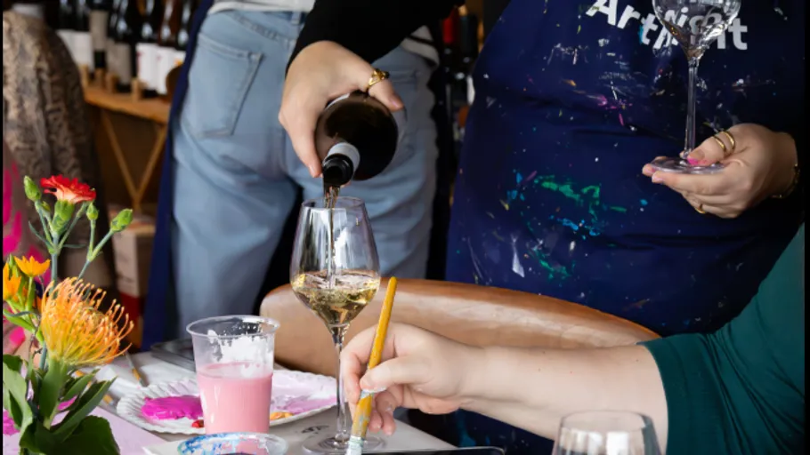 Wine poured, person painting in studio.