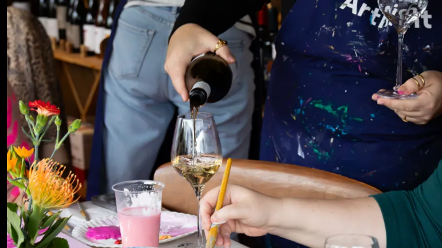 Person schenkt Wein bei Malaktivität ein.