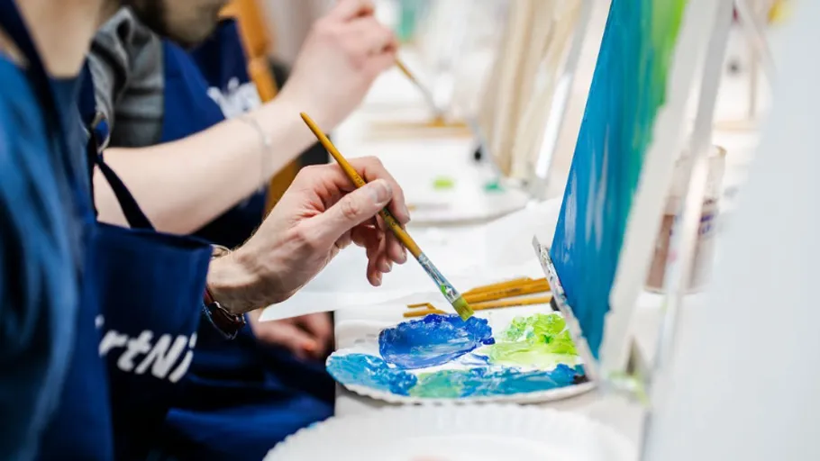 People painting on canvases in a class.