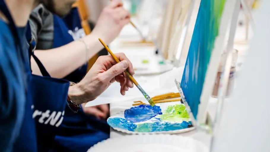 Person painting on canvas at workshop.