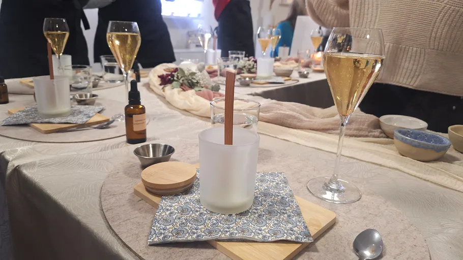 Table with glasses, candles, and a bottle.