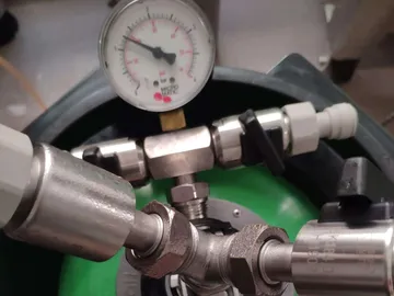 Manometer misst Druck auf einem Druckbehälter mit Anschlüssen.