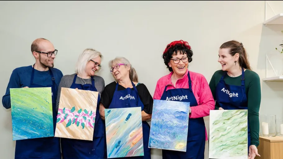 Five people smiling while holding their paintings.