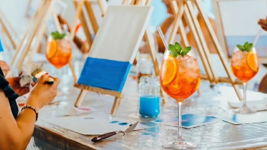 Cocktailglas mit Malerei im Hintergrund.