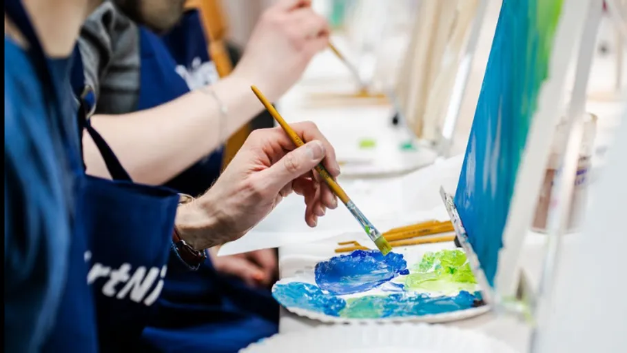 Person painting on canvas with paintbrush.