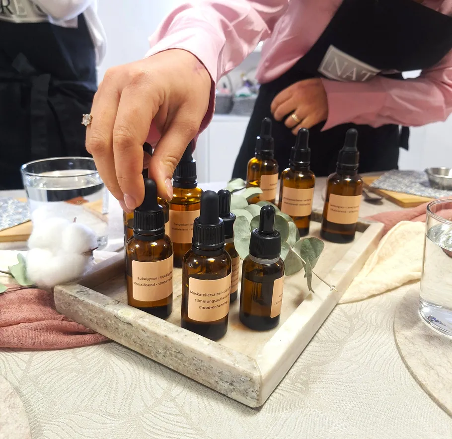 Person selecting essential oil bottle on tray.