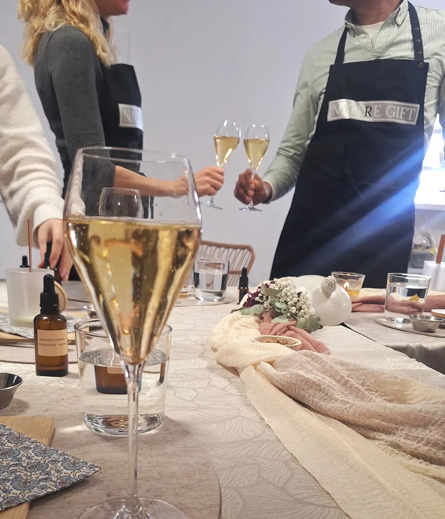 Personen stoßen mit Sektgläsern am Tisch an.