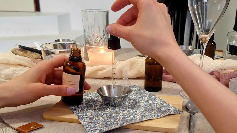 Hände verwenden Pipette mit Öl in einer Schüssel.