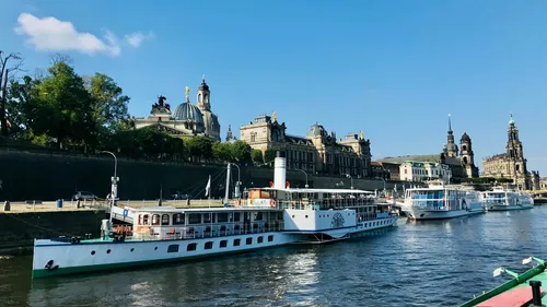 Riverboats docked beside scenic historic buildings.