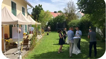 Menschen unterhalten sich in sonnigem Garten.