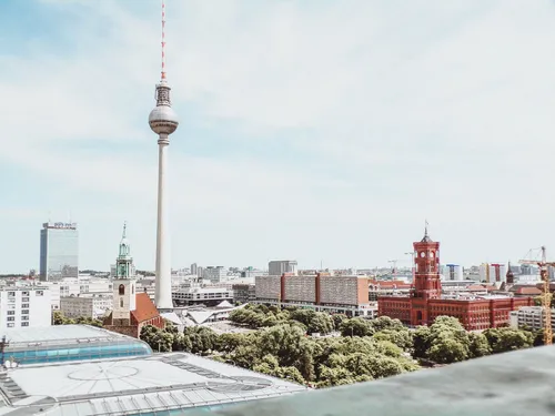 Berlin TV Tower rises above an urban landscape.
