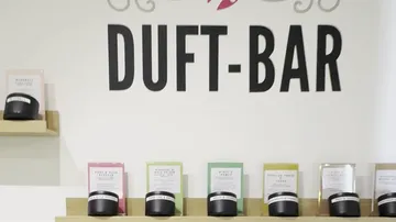 Regale mit Kerzen unter 'DUFT-BAR' Schild.