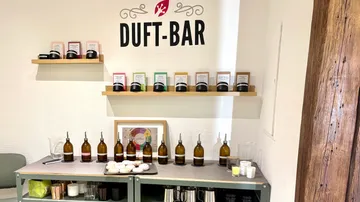 Duftbar-Anzeige mit Flaschen und Regalen.