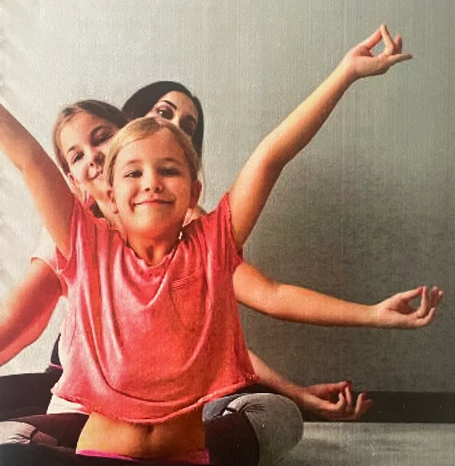 Three smiling people doing yoga poses together.