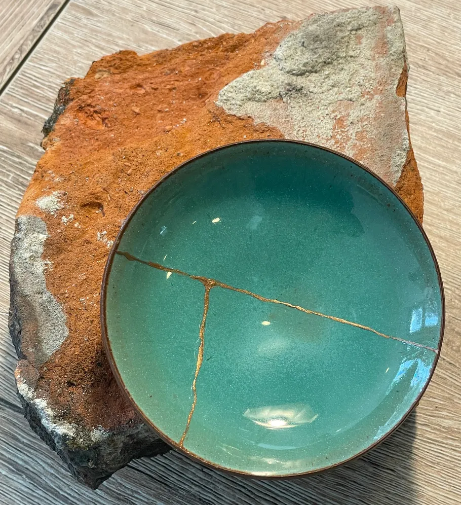 Keramikschale mit Goldrissen auf Stein.