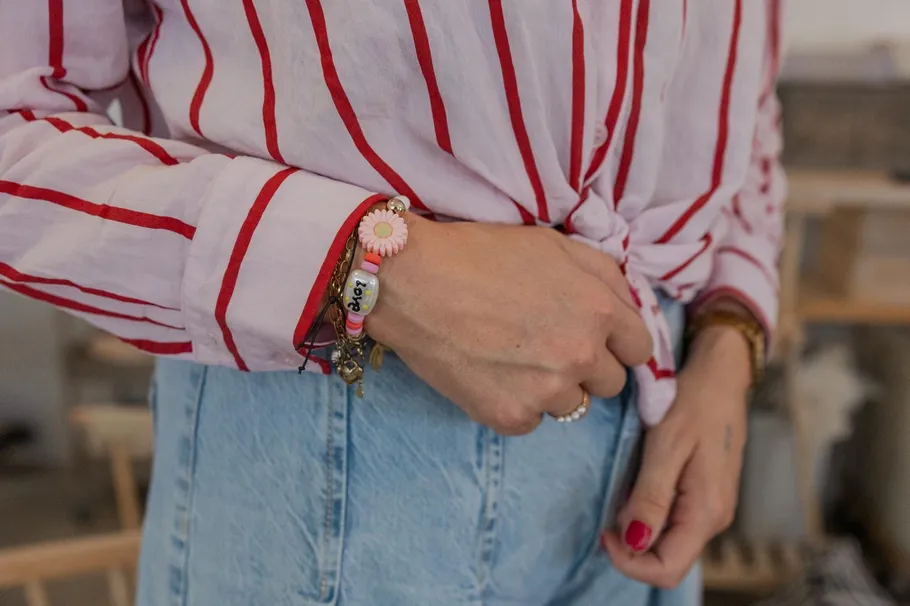 Person trägt gestreiftes Hemd und Armbänder innen.