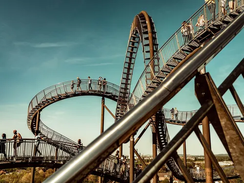 Spinning viewing platform with people under blue skies.
