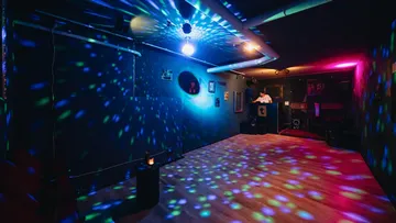 Empty dance floor with colorful disco lights.