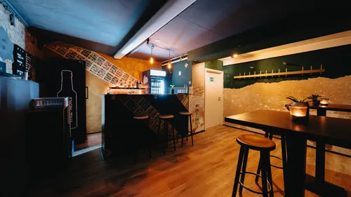 Cozy bar interior with stools and warm lighting.