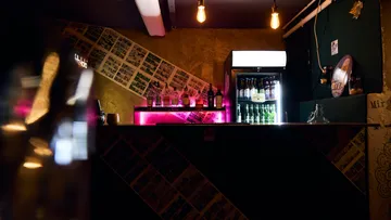 Bartheke mit Getränken und einem Kühlschrank.