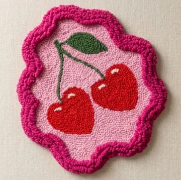 Colorful cherry-shaped embroidered patch on fabric.