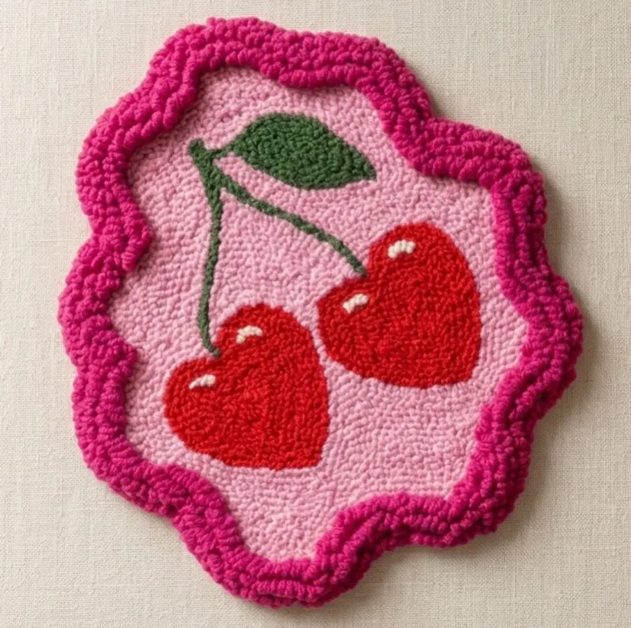 Colorful cherry-shaped embroidered patch on fabric.