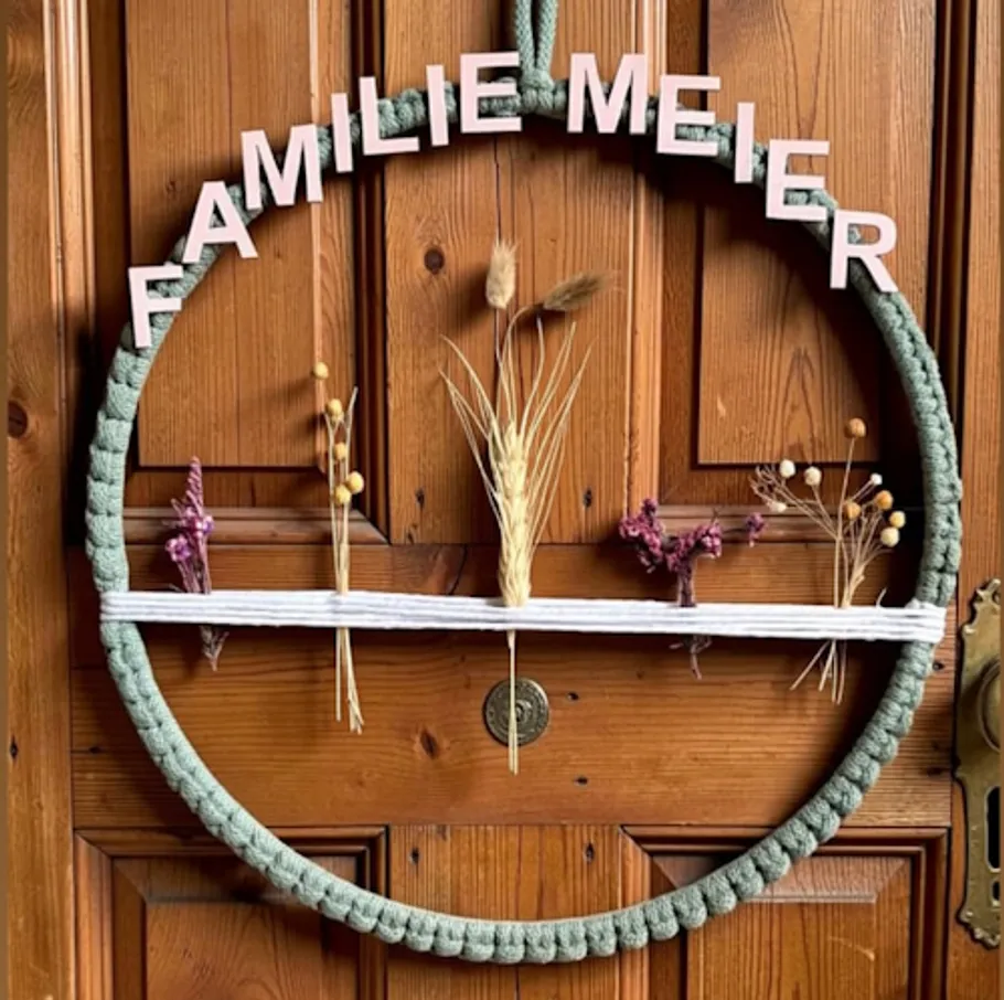 Decorative wreath with 'Familie Meier' on wooden door.